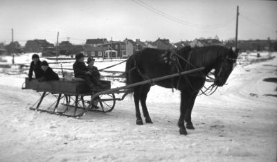 Children playing on a horse-drawn sleigh used to haul ice